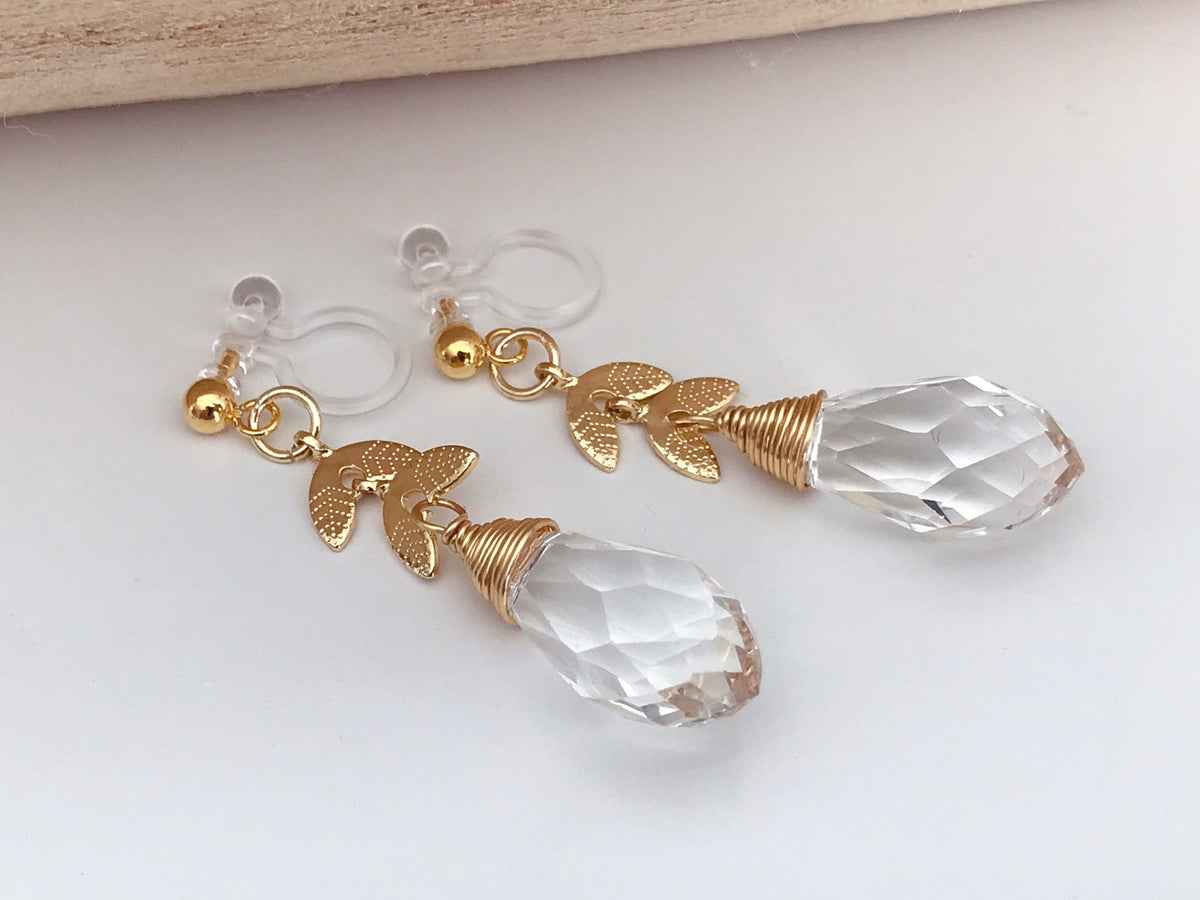 Gold leaf chain dangling ear clips with transparent faceted pearl in the shape of a drop of water Comfortable invisible clips.