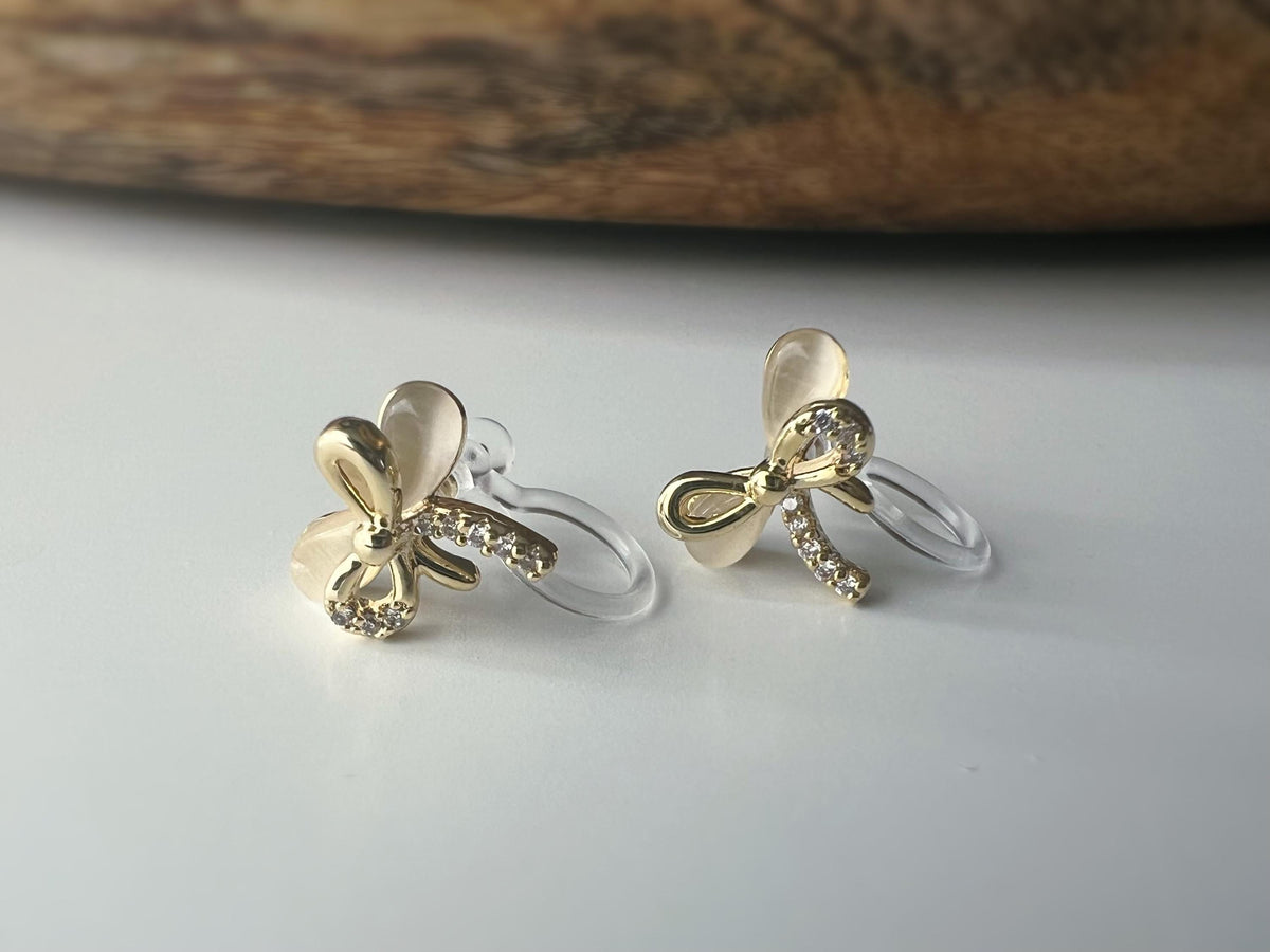 Boucles d'oreilles clip en forme de nœud doré ornées strass scintillants Délicates elles ajoutent une touche de charme raffiné à votre style