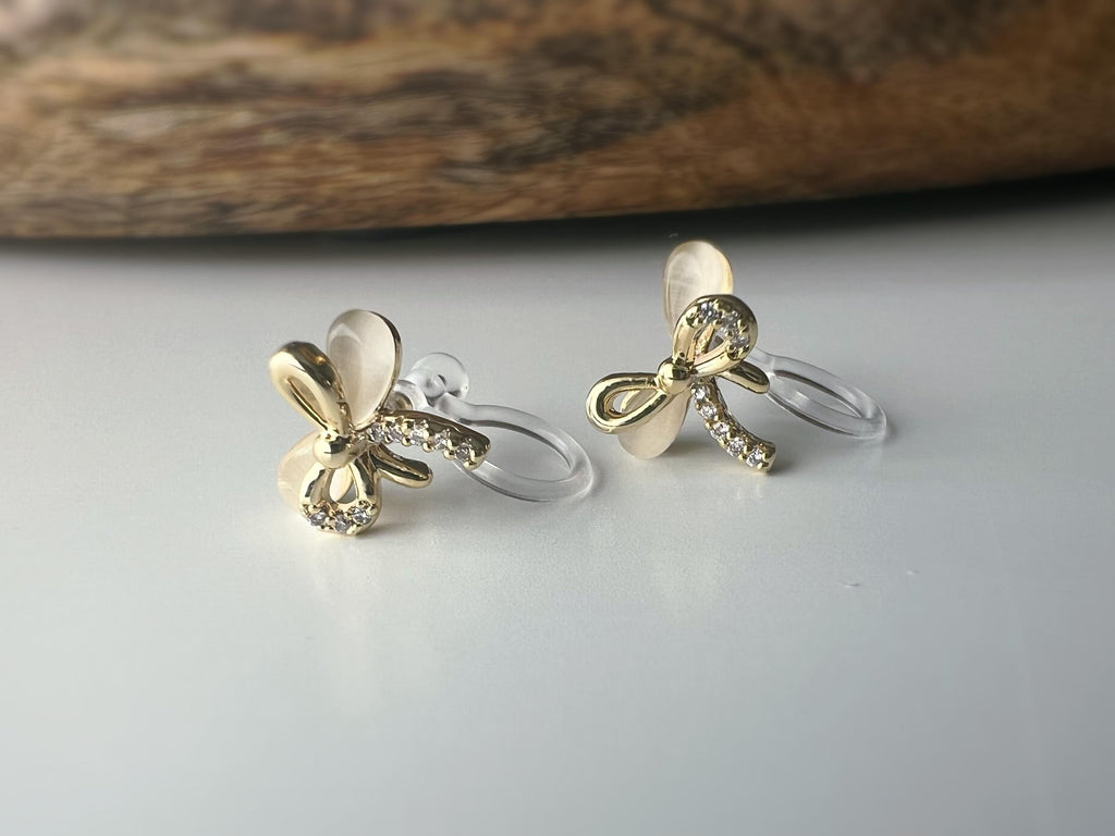 Boucles d'oreilles clip en forme de nœud doré ornées strass scintillants Délicates elles ajoutent une touche de charme raffiné à votre style