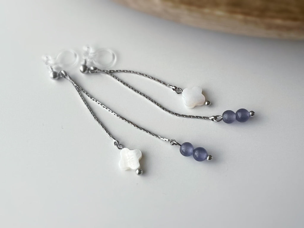 Boucles d'oreilles clip élégantes Chaîne argentée Perles violettes Fleur blanche en nacre Légères raffinées parfait pour style délicat chic.