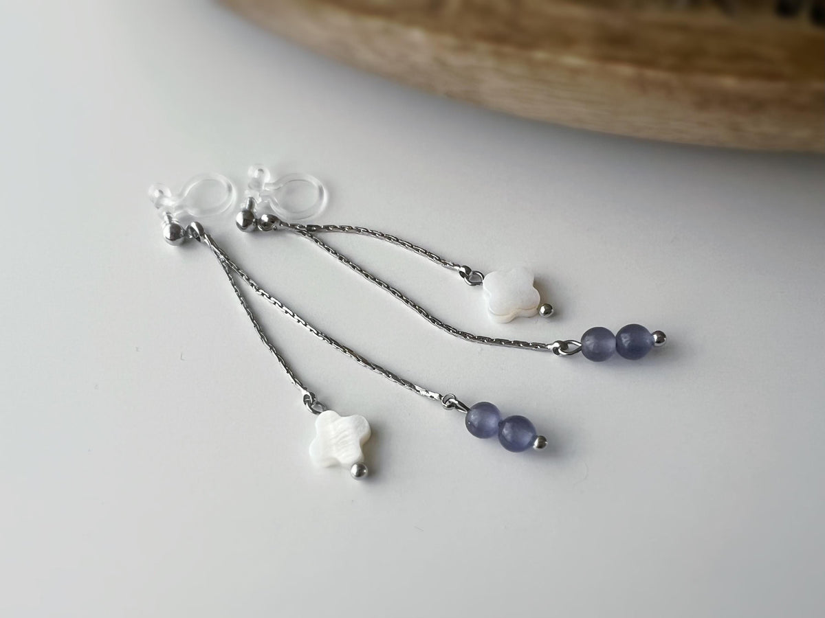Boucles d'oreilles clip élégantes Chaîne argentée Perles violettes Fleur blanche en nacre Légères raffinées parfait pour style délicat chic.