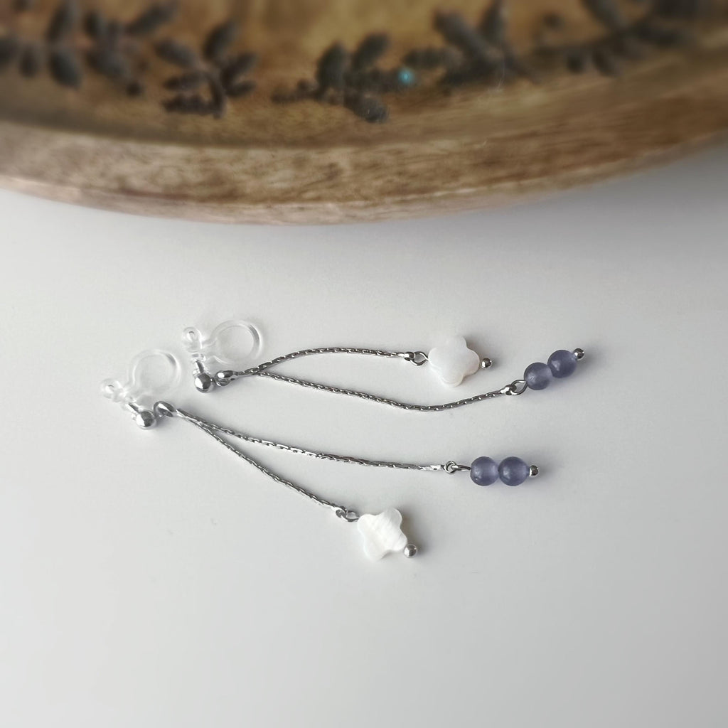 Boucles d'oreilles clip élégantes Chaîne argentée Perles violettes Fleur blanche en nacre Légères raffinées parfait pour style délicat chic.