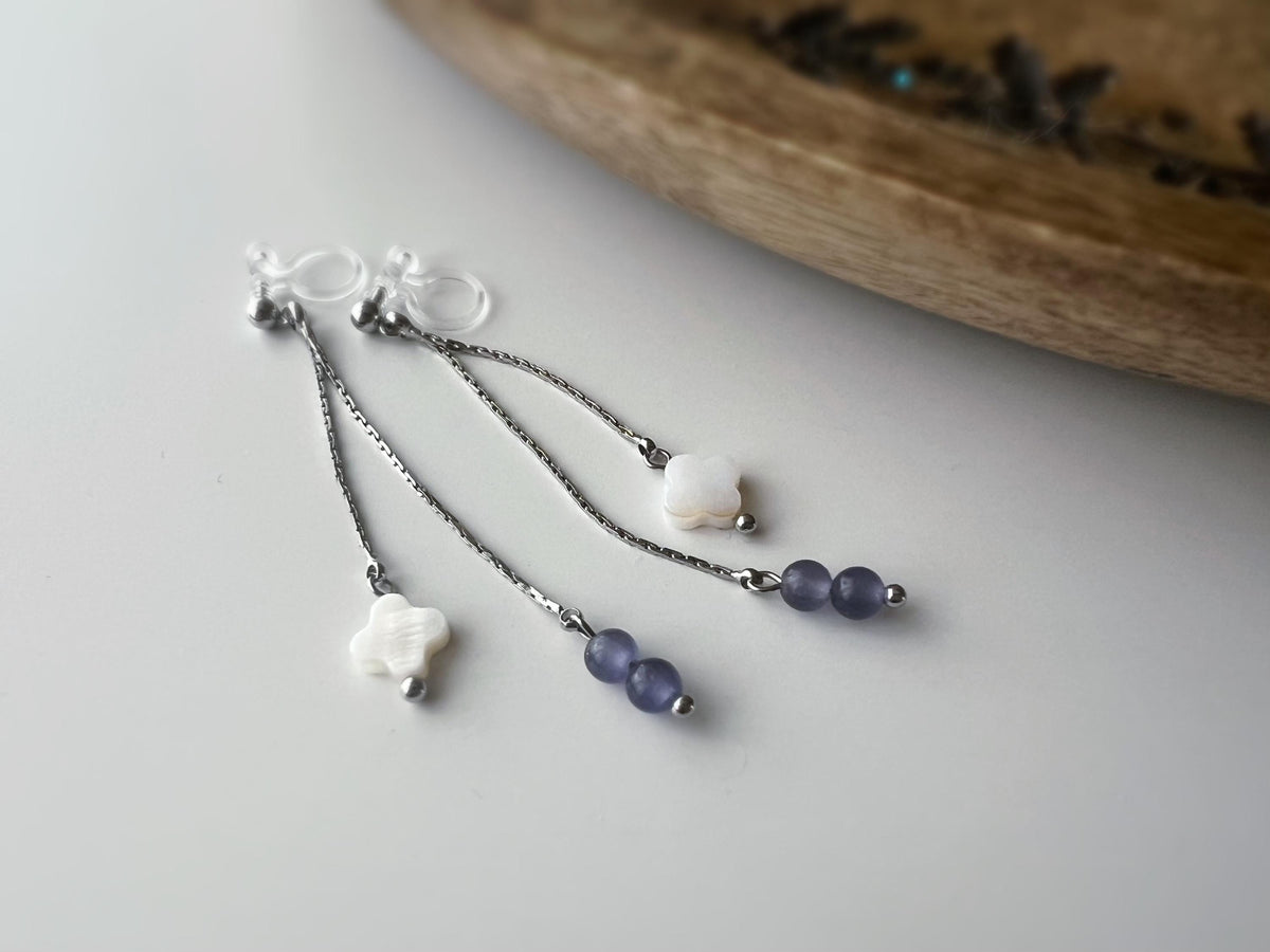 Boucles d'oreilles clip élégantes Chaîne argentée Perles violettes Fleur blanche en nacre Légères raffinées parfait pour style délicat chic.