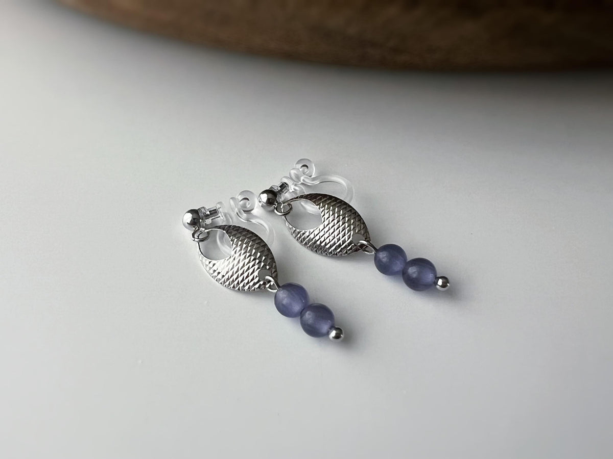 Boucles d'oreilles clip élégantes en argent avec perles violettes. Design raffiné et sans perçage, parfait pour un look chic et sophistiqué.