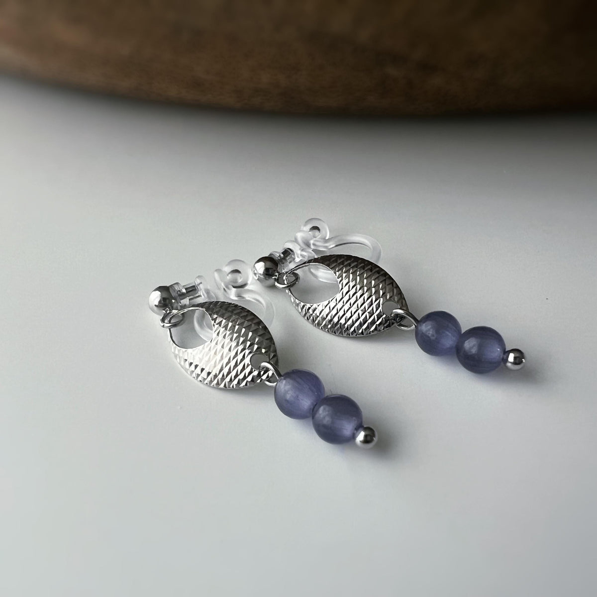 Boucles d'oreilles clip élégantes en argent avec perles violettes. Design raffiné et sans perçage, parfait pour un look chic et sophistiqué.