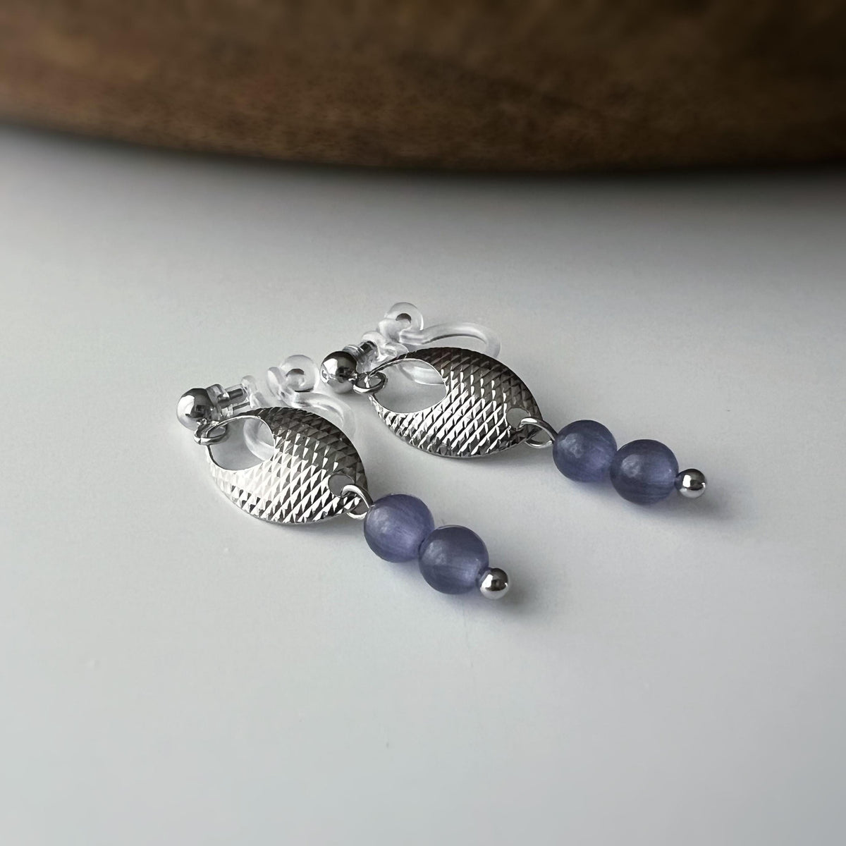 Boucles d'oreilles clip élégantes en argent avec perles violettes. Design raffiné et sans perçage, parfait pour un look chic et sophistiqué.