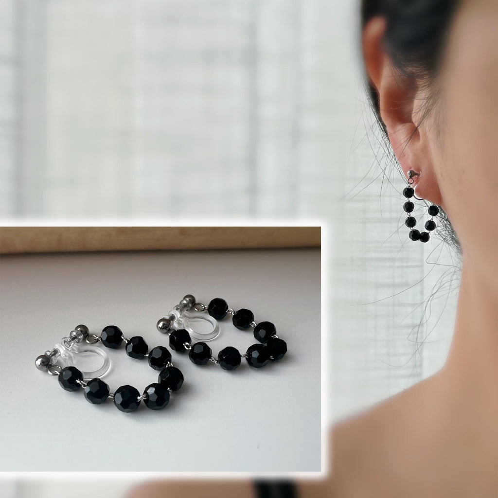 Boucles d'oreilles clips élégantes avec perles noires facettées en forme de cercle. Idéales pour un look raffiné et intemporel.