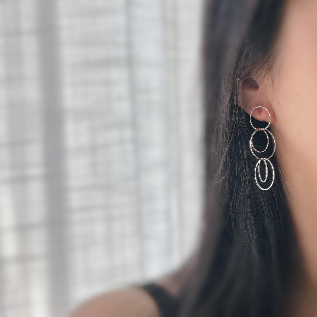 Boucles d'oreilles Clips, anneaux entrelacés argentés. Élégantes et légères, elles subliment vos looks avec une touche moderne et raffinée.