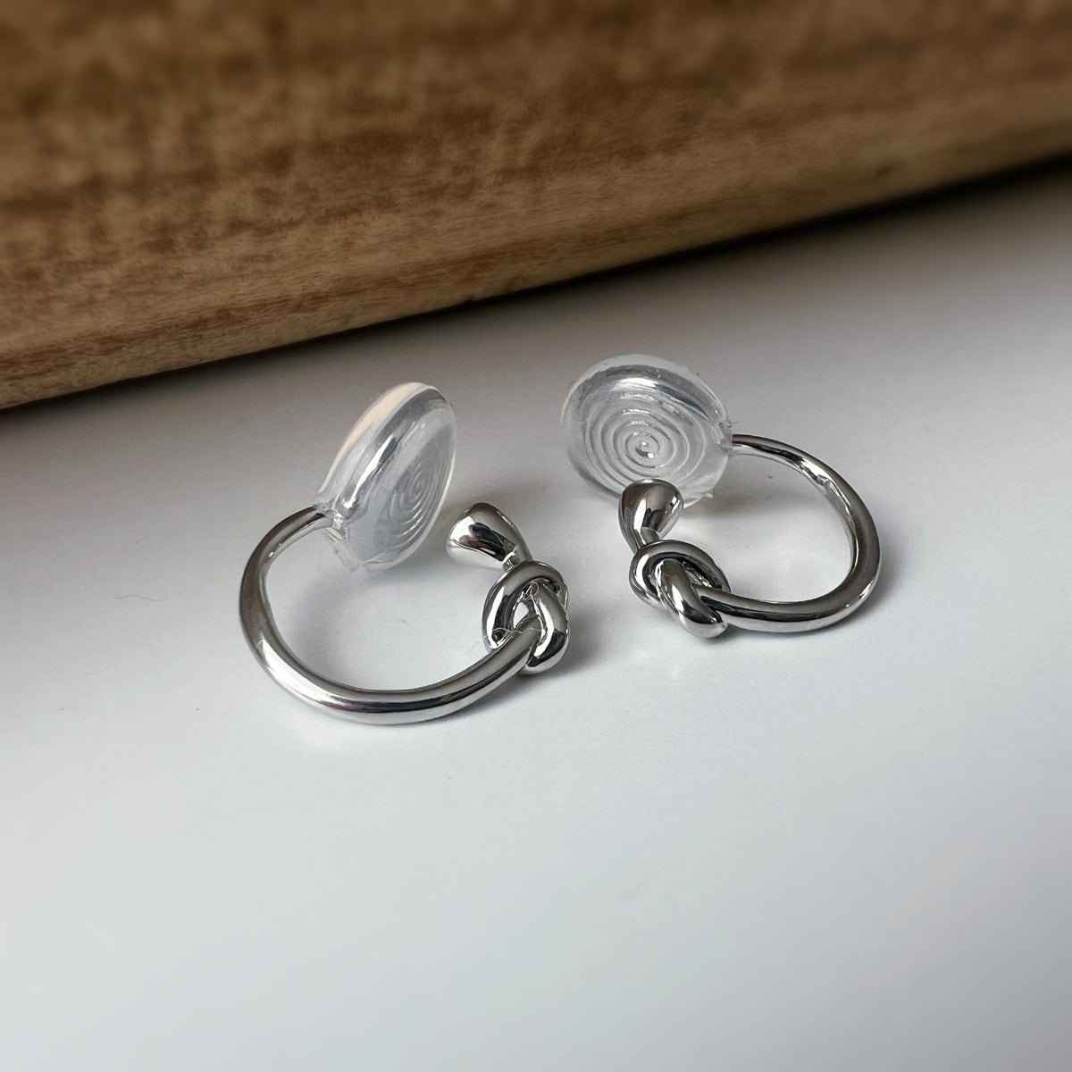 Créoles à clip minimalistes en argent ou doré, design noué élégant et discret, parfaites pour un style raffiné sans perçage d’oreilles.