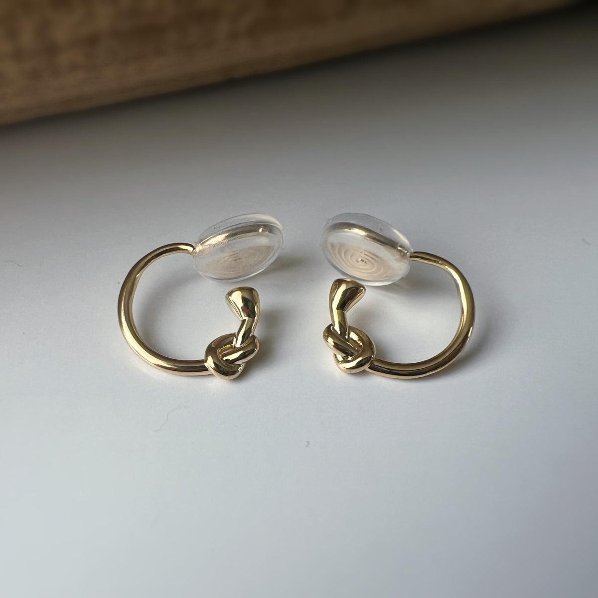 Créoles à clip minimalistes en argent ou doré, design noué élégant et discret, parfaites pour un style raffiné sans perçage d’oreilles.