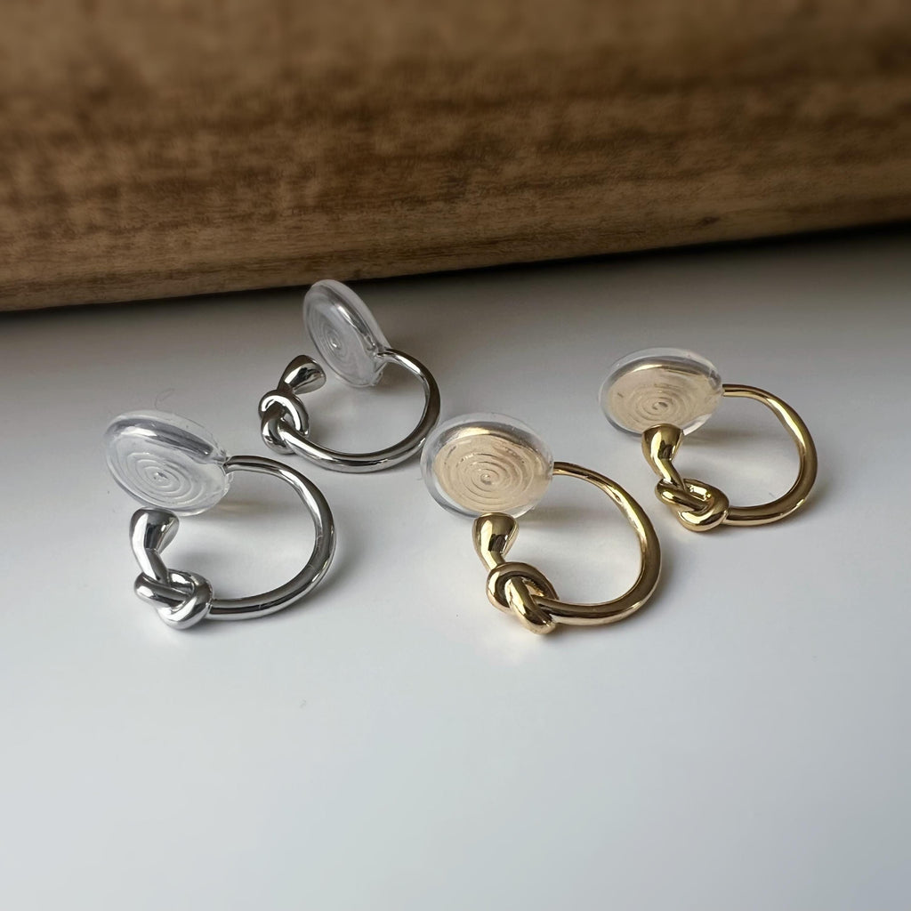 Créoles à clip minimalistes en argent ou doré, design noué élégant et discret, parfaites pour un style raffiné sans perçage d’oreilles.